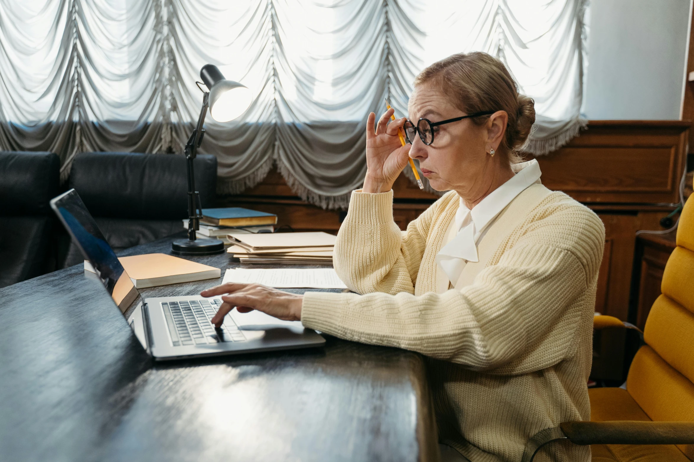 a woman sitting at a desk using a laptop computer, by Julia Pishtar, trending on pexels, looking old, russian academic, court session images, a very macular woman in white