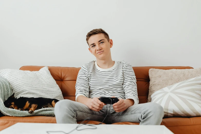 a man sitting on a couch playing a video game, by Julia Pishtar, trending on pexels, happening, portrait of 14 years old boy, non binary model, lachlan bailey, looking the camera