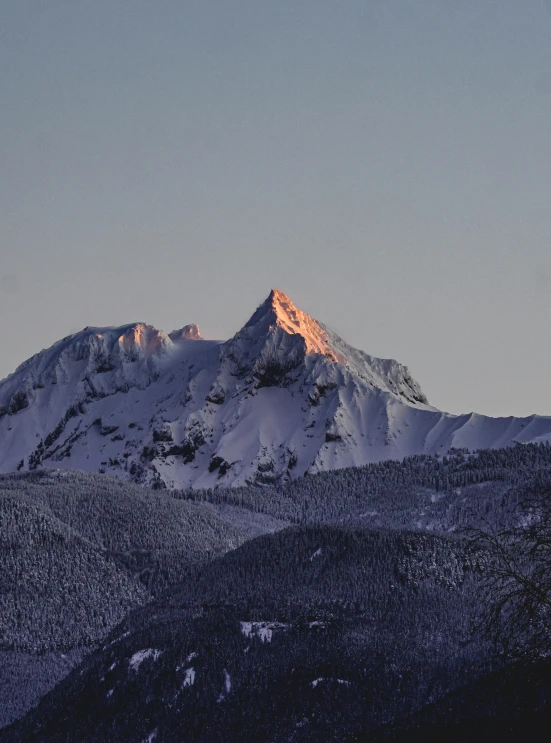 a snow covered mountain with some clouds