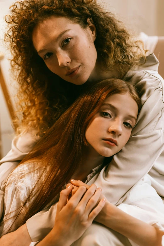 a woman sitting on top of a bed next to a young girl, inspired by Nan Goldin, trending on pexels, renaissance, long curl red hair, headshot, modest, teenage