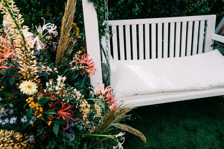 a white swing bed sitting on top of a lush green field, made of flowers, profile image, white finish, botanicals