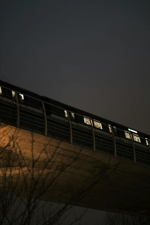 a nighttime s of the train tracks as it crosses over the bridge