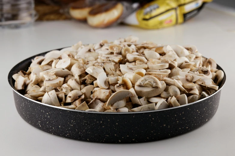 a pan filled with mushrooms sitting on top of a counter, detailed product image, 3 / 4 wide shot, fan favorite, ground - level medium shot