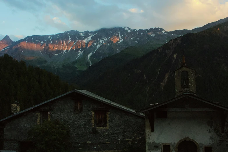 a church with a mountain in the background, inspired by Peter Zumthor, pexels contest winner, les nabis, evening light, panorama, alessio albi, old village