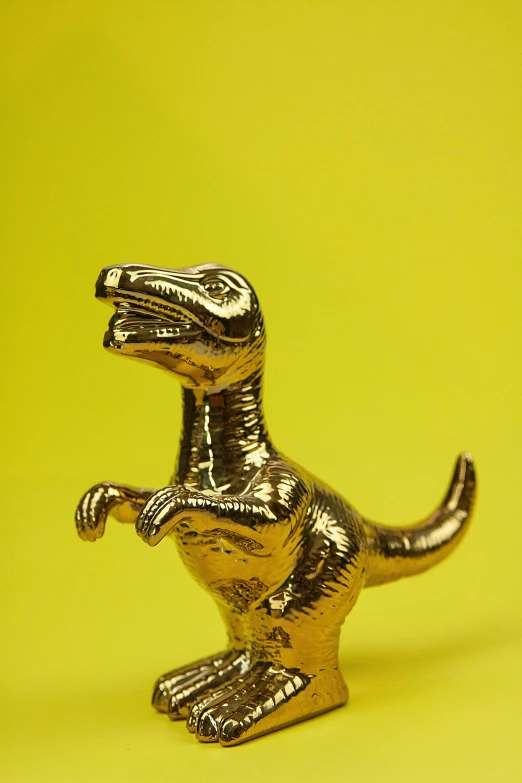 a toy t - rex on a yellow background, trending on unsplash, magic realism, made of polished broze, 24k, 1981, made of glazed