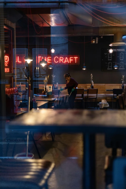 blurry image of people inside a restaurant next to neon signs
