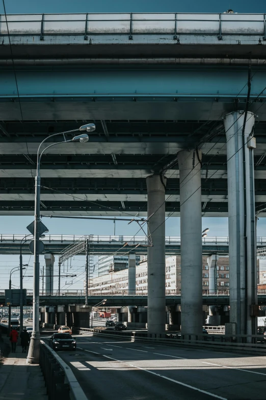 a street filled with lots of traffic under a bridge, by Tobias Stimmer, unsplash, concrete pillars, monorail station, neo norilsk, high quality photo