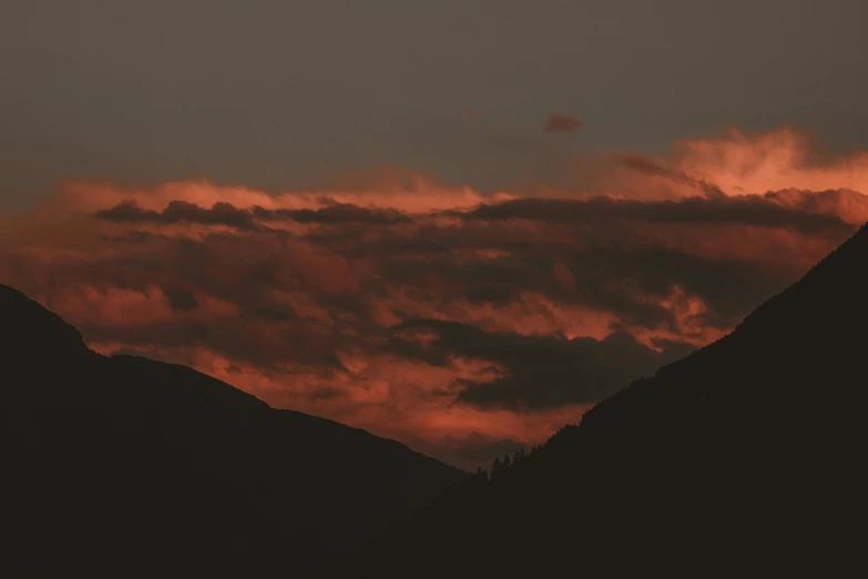 the sun is setting over a mountain range, by Attila Meszlenyi, pexels contest winner, romanticism, red stormy sky, whistler, grey, low angle photograph