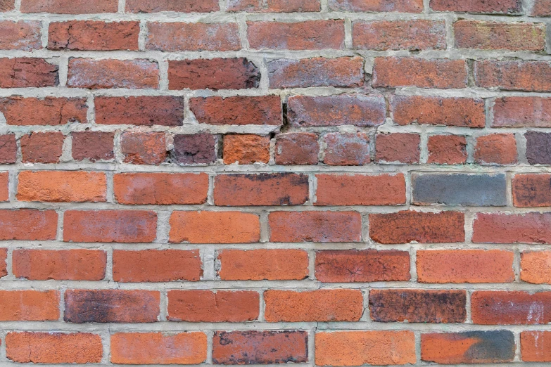 an old red brick wall with cement chippings