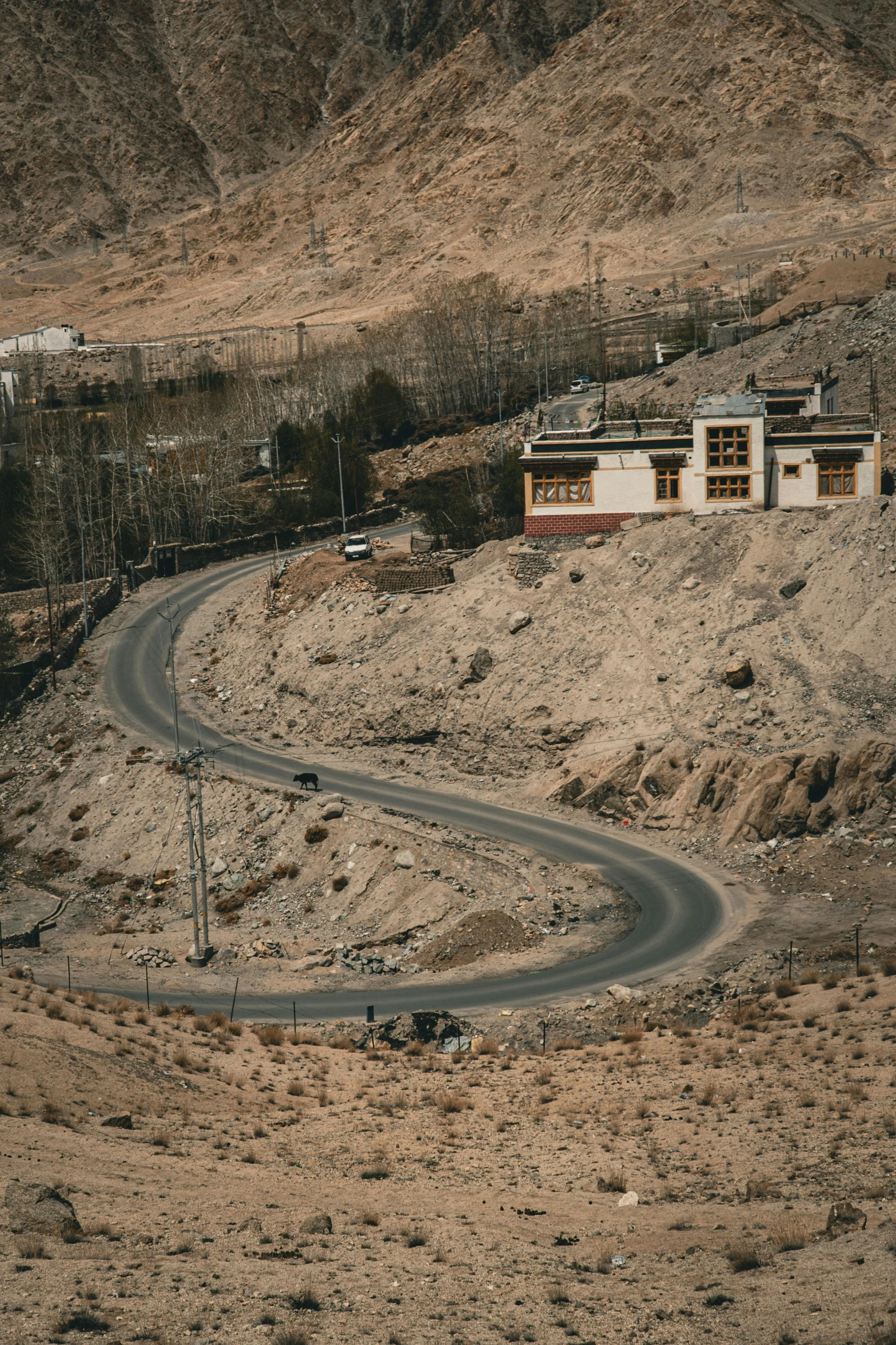 a winding road in the middle of a desert, trending on unsplash, nepali architecture buildings, military outpost, a 35mm photo, winter