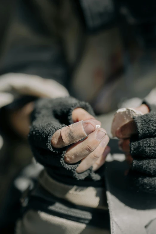 a close up of a person holding a pair of gloves, by Adam Marczyński, trending on unsplash, hyperrealism, film still of manny pacquiao, working in the forge, wounded soldiers, raku