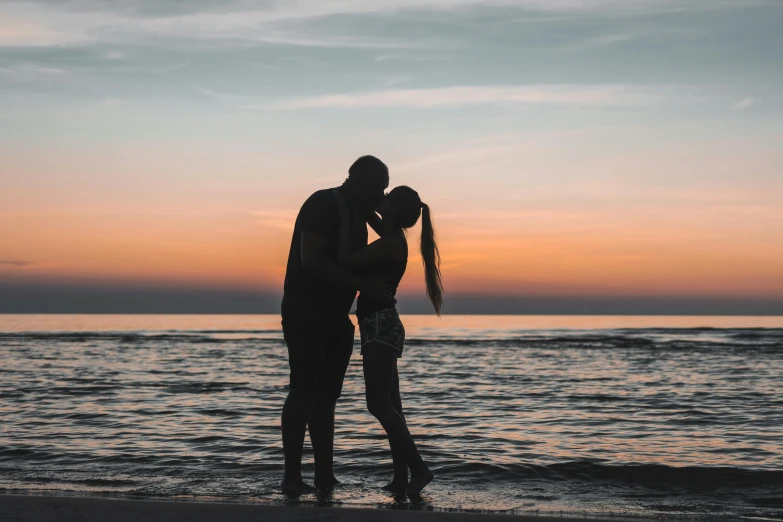 a couple kissing on the beach at sunset, pexels contest winner, black, unfinished, sydney hanson, stand up with the sea behind