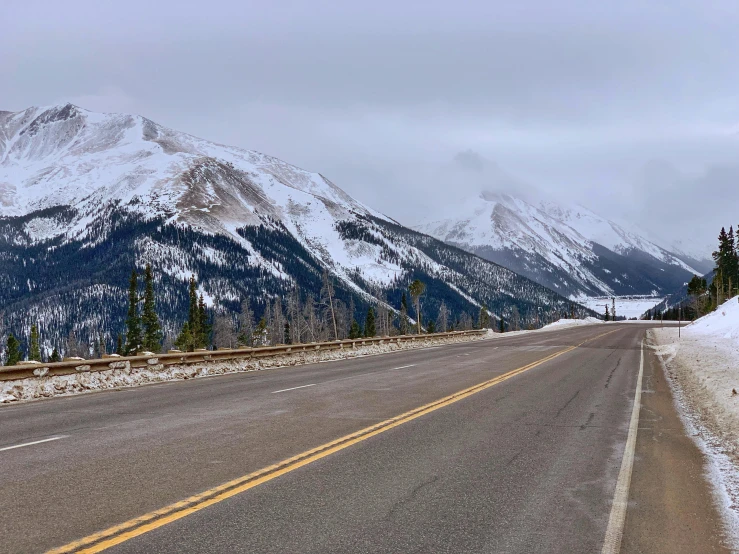 snowy mountains on the side of a road