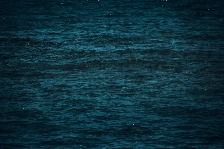 a person on a surfboard in the middle of the ocean, inspired by Elsa Bleda, hurufiyya, midnight blue, ignant, abstract photography, blue image