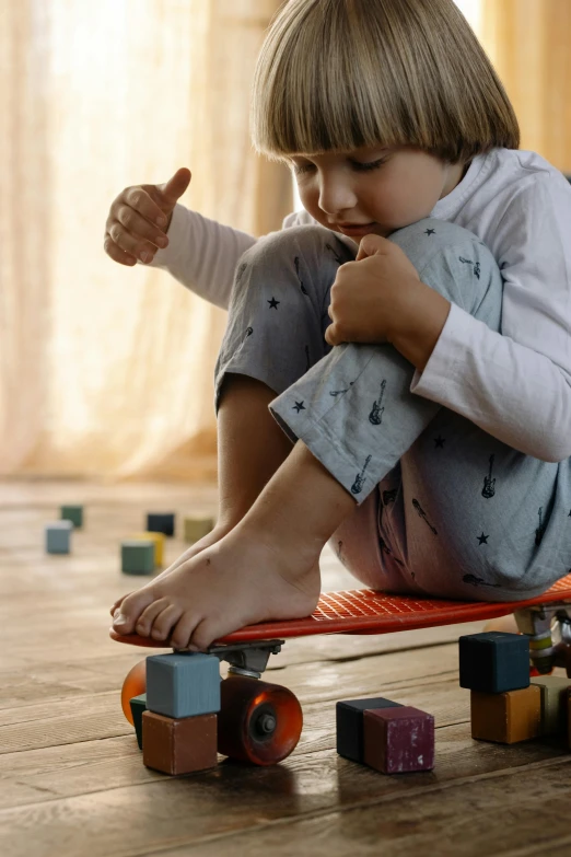 a  sitting on top of a skateboard