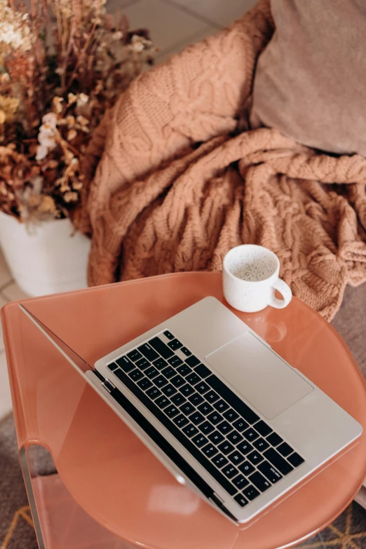 a laptop computer sitting on top of a glass table, muted fall colors, sitting on a mocha-colored table, thumbnail, orange pastel colors