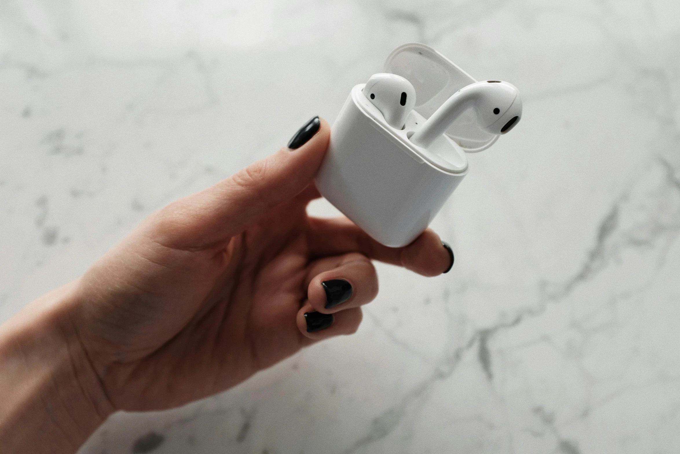 a person holding an apple airpods in their hand, by Christen Købke, trending on pexels, square, glossy white metal, homemade, highly accurate