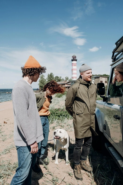 a group of people standing next to a vehicle, by Christen Dalsgaard, pexels contest winner, wearing hunter coat, lighthouse, mr beast, picnic