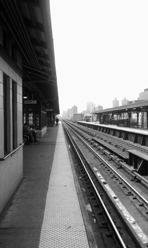 a long empty train station with rails running alongside it