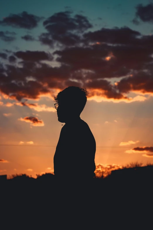 a silhouette of a person standing in front of a sunset, profile image