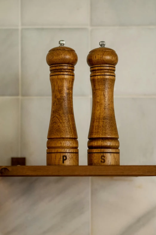 a couple of pepper grinds sitting on top of a shelf, inspired by Gordon Browne, unsplash, close up front view, wooden staff, showers, 15081959 21121991 01012000 4k