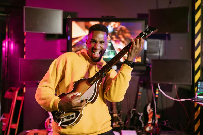 a man that is playing a guitar in a room, wakanda, smiling, key still, liam brazier