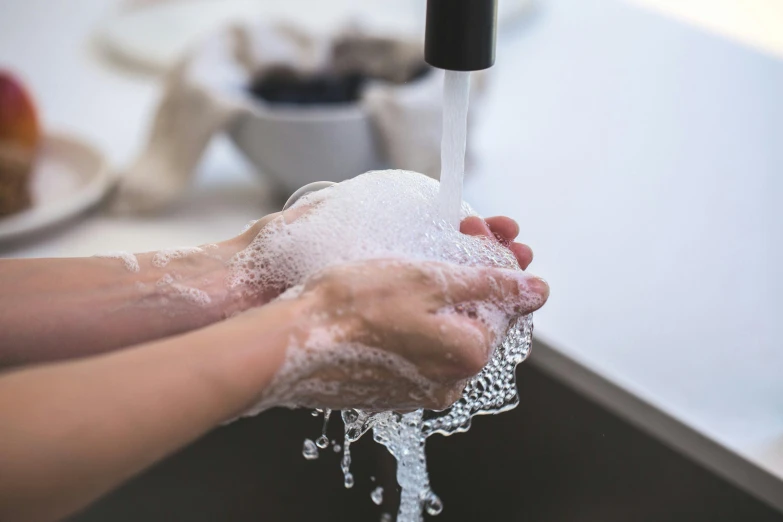 a person washing their hands in a kitchen sink, a stipple, pexels, carved soap, hydration, fan favorite, puffy