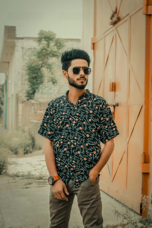 a man standing in front of a building, an album cover, by Daarken, pexels contest winner, floral clothes, candid!! dark background, summer shirt, indian