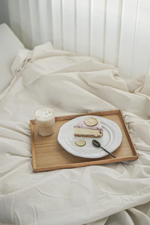 food and drink sit on top of a small plate on the bed