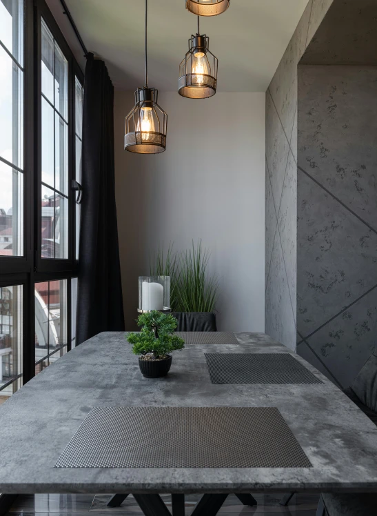 a concrete dining room table with modern glass pendant lights