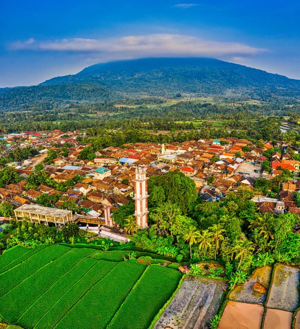 an aerial view of a town with a mountain in the background, by Basuki Abdullah, shutterstock, sumatraism, square, myllypuro water tower, an ancient, 8k uhd”