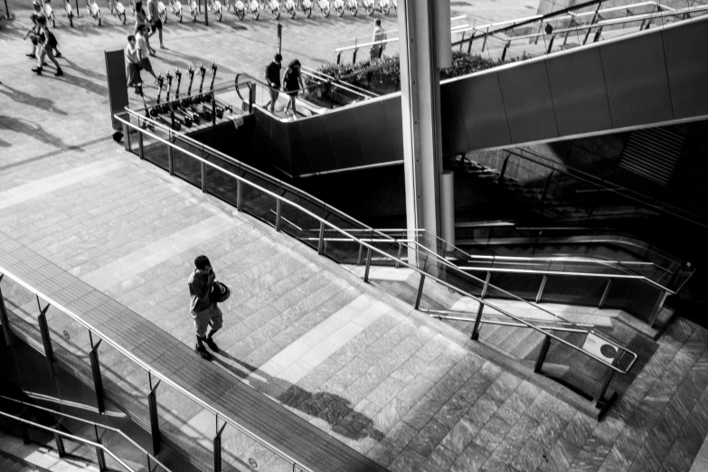 a black and white photo of a person on an escalator, by Daniel Gelon, pexels contest winner, in neotokyo, panoramic view of girl, on ground, terminal