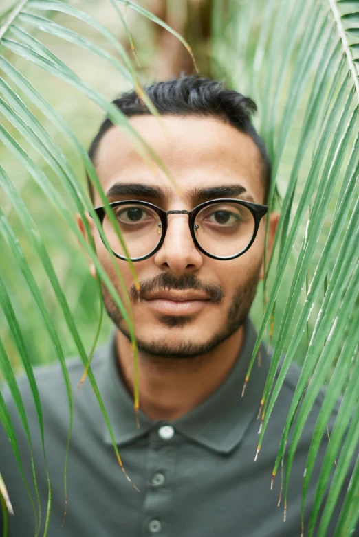 a man standing in front of green plants