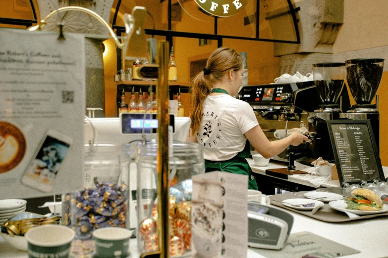 a woman making a cup of coffee in a coffee shop, by Julia Pishtar, starbucks aprons and visors, milan jozing, thumbnail, cash register