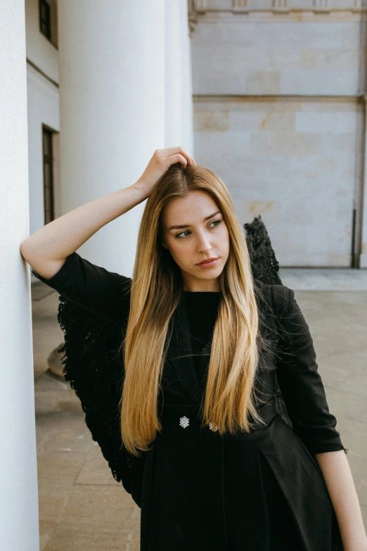 a woman leaning against a wall with her hands on her head, inspired by Elsa Bleda, pexels contest winner, renaissance, long straight blonde hair, wearing black modern clothes, in front of white back drop, russian girlfriend