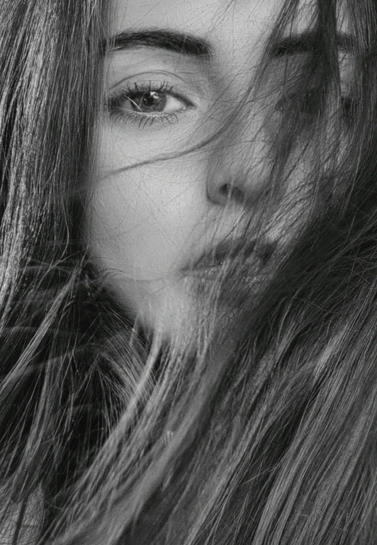 a black and white photo of a woman with long hair, fine art, hiding, close - up of face, cool tousled hair, youthful face