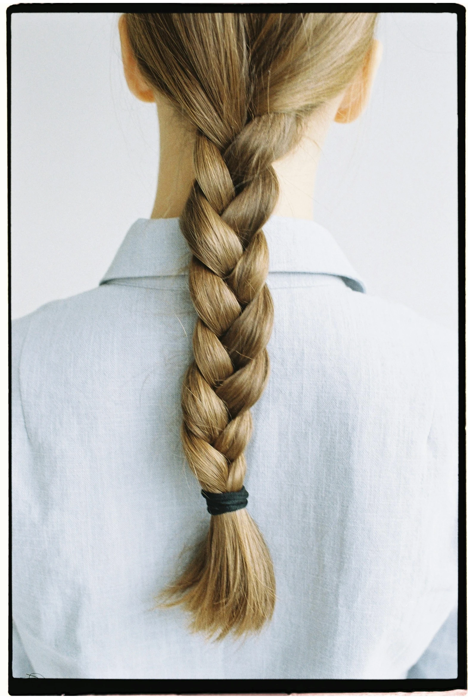 a woman with a long braid in her hair, inspired by Josefina Tanganelli Plana, trending on pexels, in style of ren hang, light brown hair, like a catalog photograph, early 2 0 0 0 s