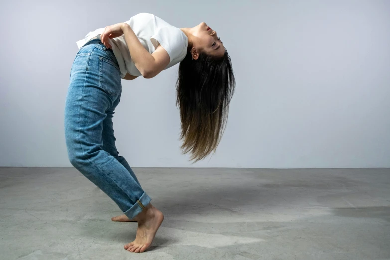 a young woman stretches in a pose on the concrete floor