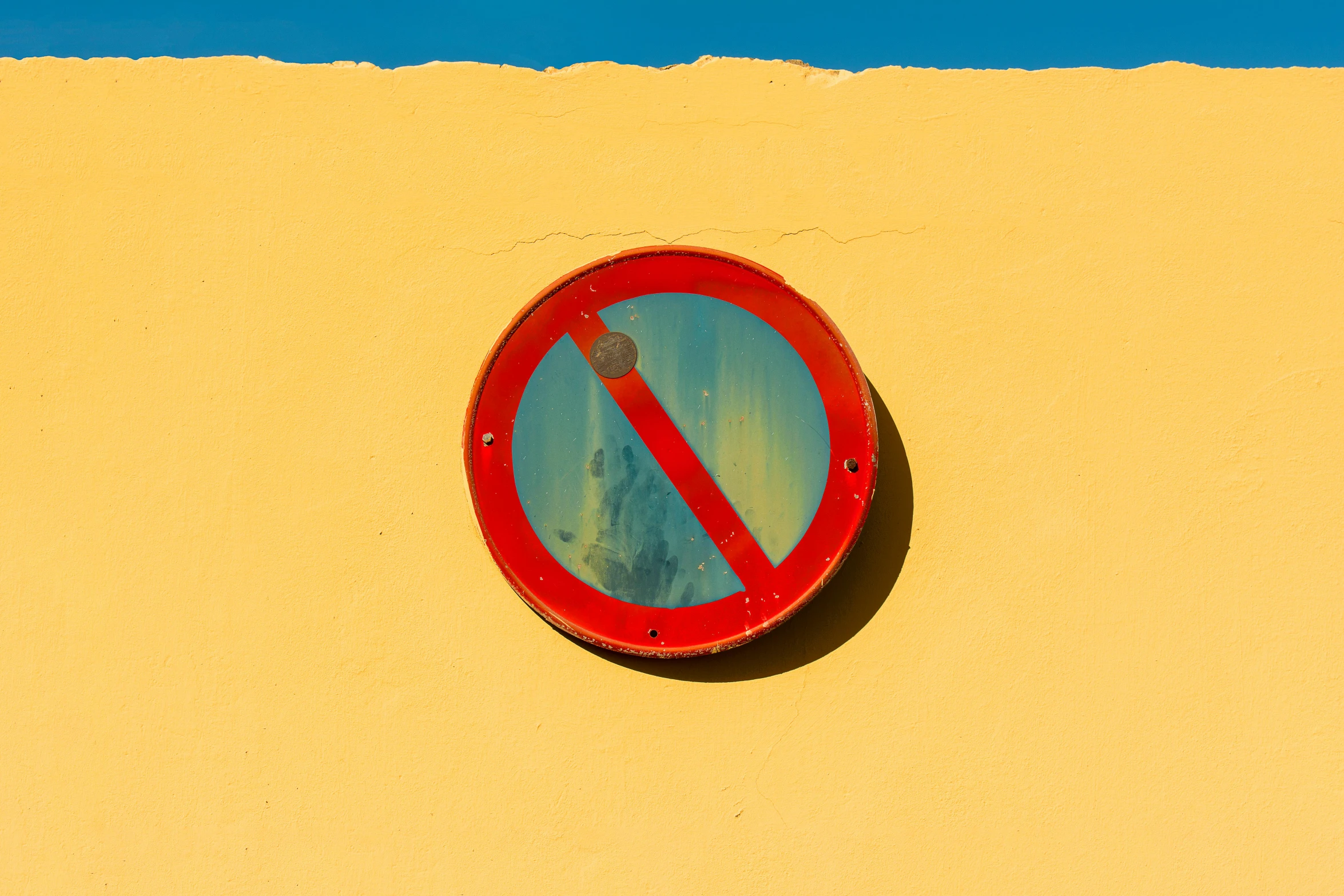 a red and white sign on a yellow wall, a picture, by Jan Rustem, unsplash, postminimalism, looking at porthole window, no - text no - logo, blue sky, no light reflecting off paint