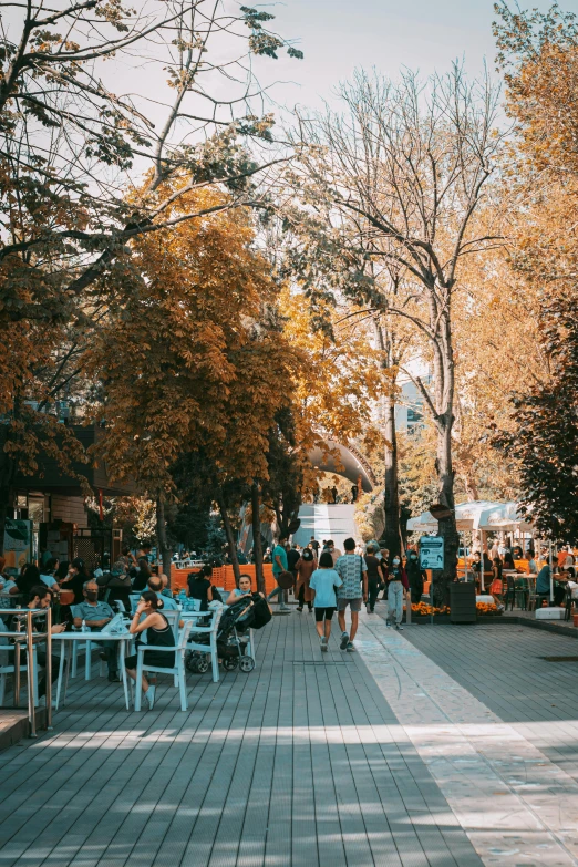 a woman walking down a sidewalk in the park