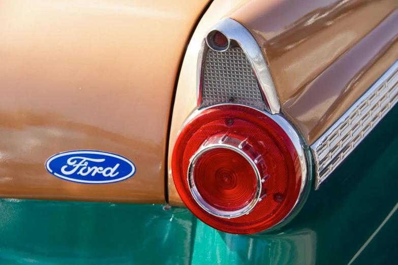 the rear end of a ford logo on an old green car