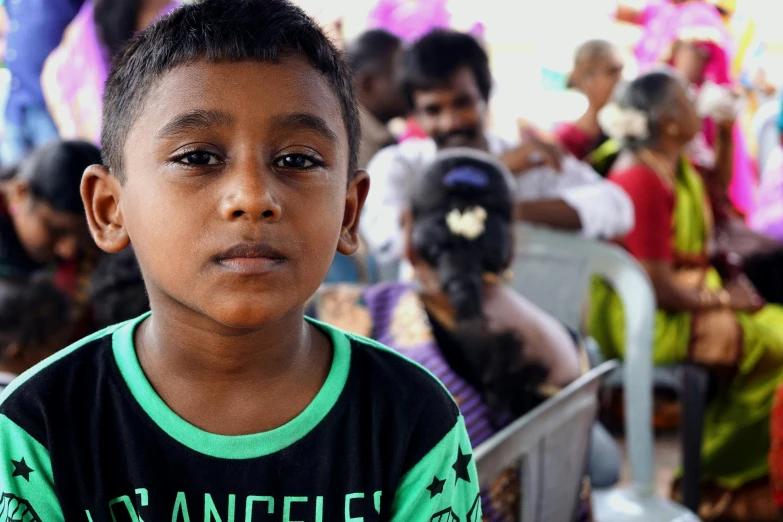 a young boy standing in front of a crowd of people, pexels contest winner, hurufiyya, sri lanka, square, medium closeup, 15081959 21121991 01012000 4k