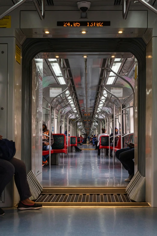 a couple of people sitting on top of a train, adjacent hallways, view from inside, in a row, you can see all the passageways