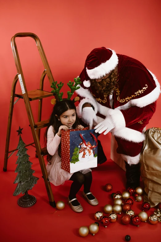 a child holding onto a santa clause christmas gift bag