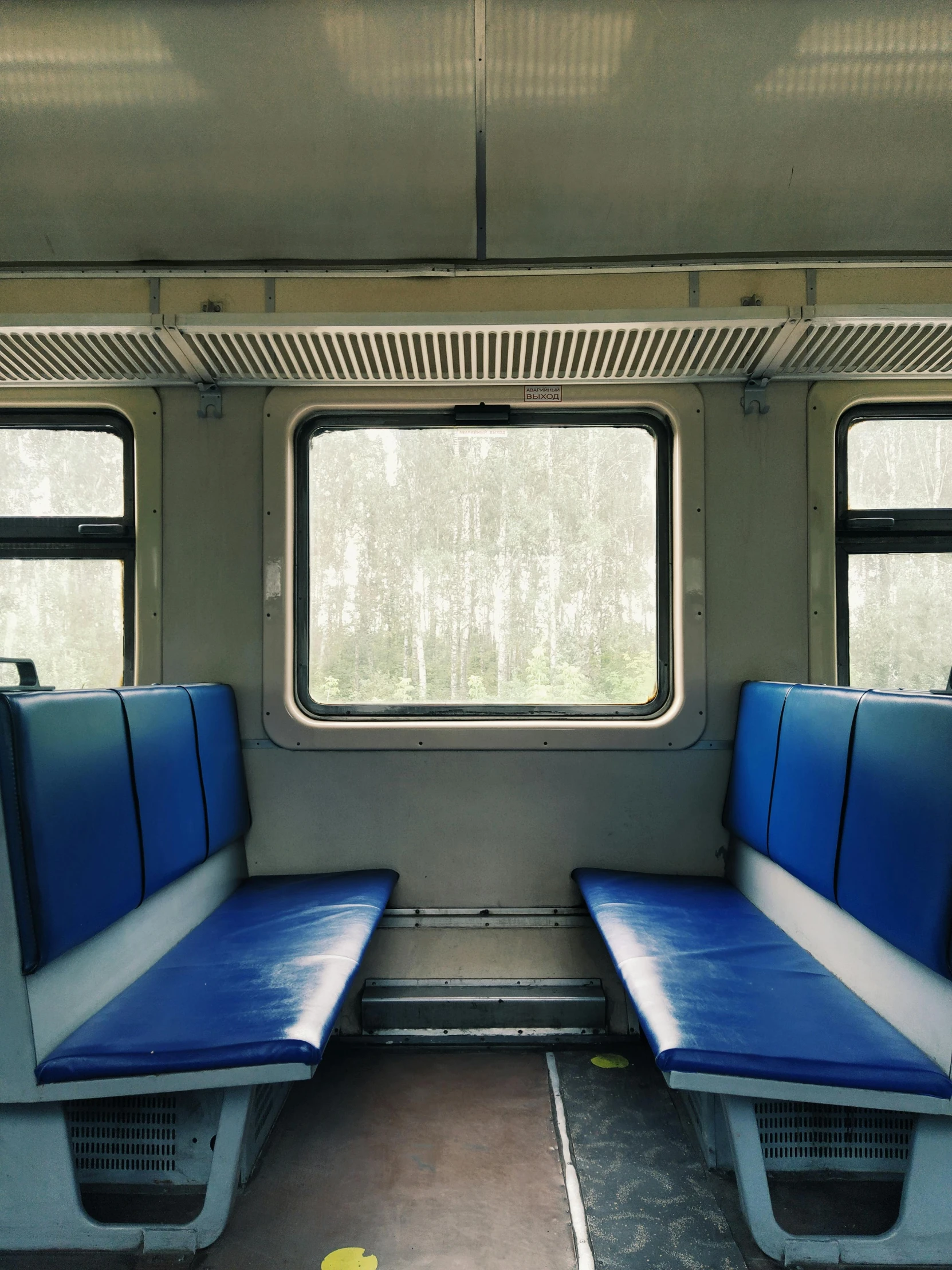 a couple of blue seats sitting next to each other, a portrait, by Attila Meszlenyi, unsplash, train window, photo on iphone, near forest, 2000s photo