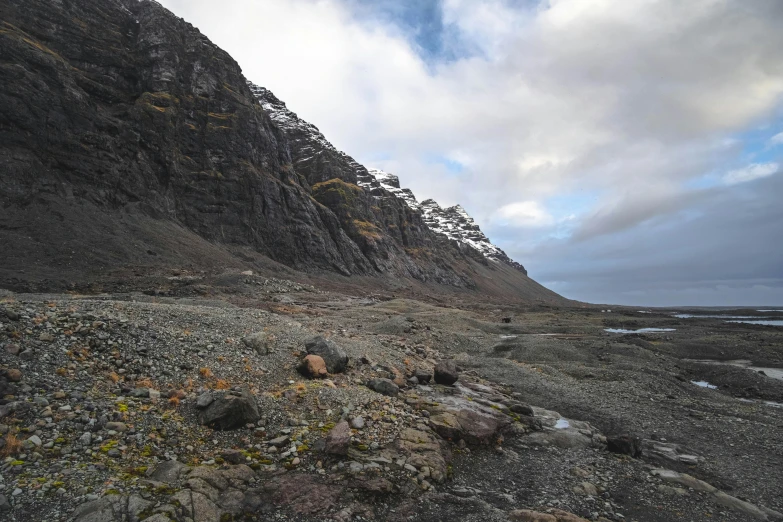 a sandy beach area next to a mountain