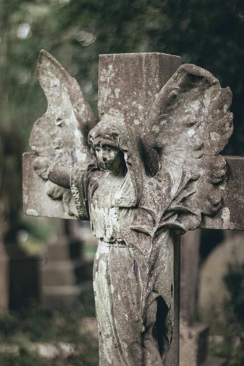 a statue of an angel on a cross in a cemetery, pexels contest winner, paul barson, 1900s photo, a quaint, wings
