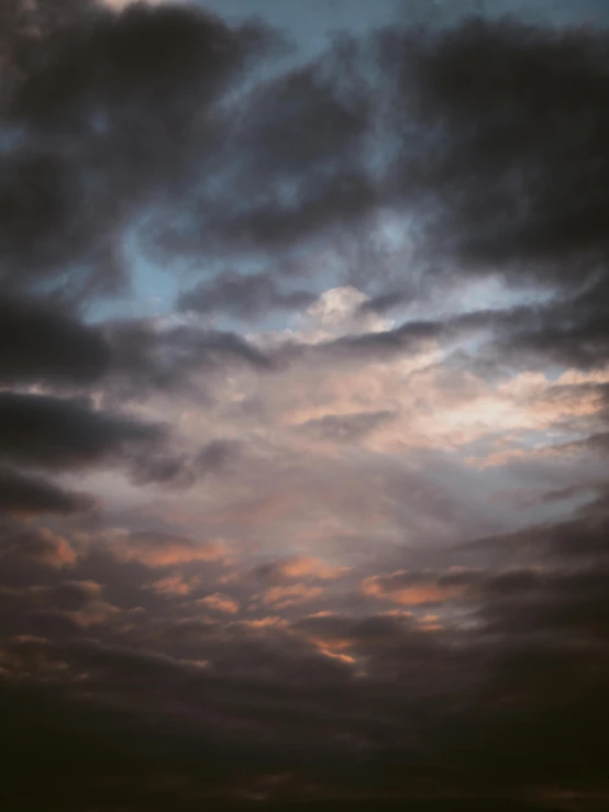 cloudy skies with a plane in the distance