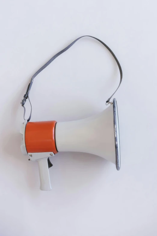 an orange and white megaphone on a white surface, by Carey Morris, holster, 1960s-era, protest, grey