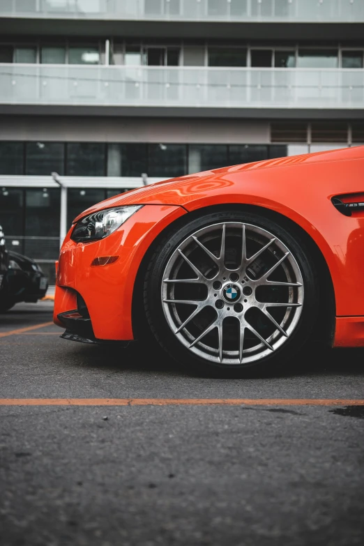 orange bmw vehicle parked near building on asphalt